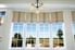 A set of brown roman shades fitted to tall windows.