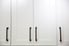 Pristine white cabinets with dark metal handles.
