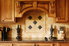 kitchen with custom wooden cabinets and natural toned tile backsplash