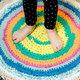 Person standing on a round fabric rug