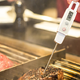 digital meat thermometer inserted into meat