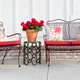 Metal patio furniture with red cushions.