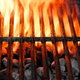 A grill grate with flames blazing from below.