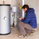 Man looking at electronic tablet while near water heater