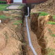 A sewage drain pipe in a trench.
