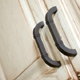 Dark handles contrast well against whitewashed kitchen cabinets doors.