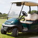 A golf cart on a golf course green.