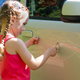 A little girl scratches a car.