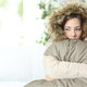 Woman in a coat squeezing a large pillow