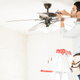 A man adjusts the settings on a ceiling fan.