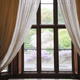 Window with two sets of curtains looking out to garden