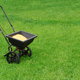 Seed spreader full and sitting on a lawn