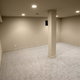 finished basement with carpeting floor and beige walls.