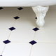Vintage-style, checkered tile floor in a bathroom, beneath a claw foot tub.