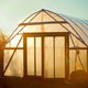 A garden greenhouse glowing in the sunset.