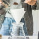 person preparing to make drip coffee with a glass device and filter