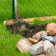 Stones and tools stand by for building a flowerbed border.