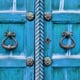 Decorative doorknobs on a blue door.