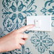 A light switch against wallpaper.