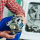 A man holds a washing machine motor.