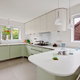 Kitchen with white laminate countertops and green cabinets
