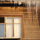 An old house with icicles and an open window. 