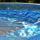 inflatable swimming pool being refilled with a water hose