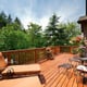 The afternoon sun shines on a back deck overlooking a slope.