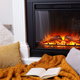 electric fireplace with cozy pillows and blanket