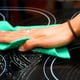 Cleaning a glass cooktop with a turquoise rag.