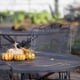 A metal patio table with pumpkins on it. 