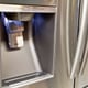 A water and ice dispenser in the door of a stainless steel refrigerator.