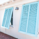 White house with two light blue Bahama shutters