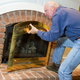 Man replacing a fireplace front cover