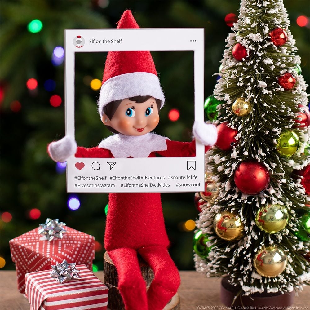 Elf on the Shelf holds up a printable Instagram photo frame. 