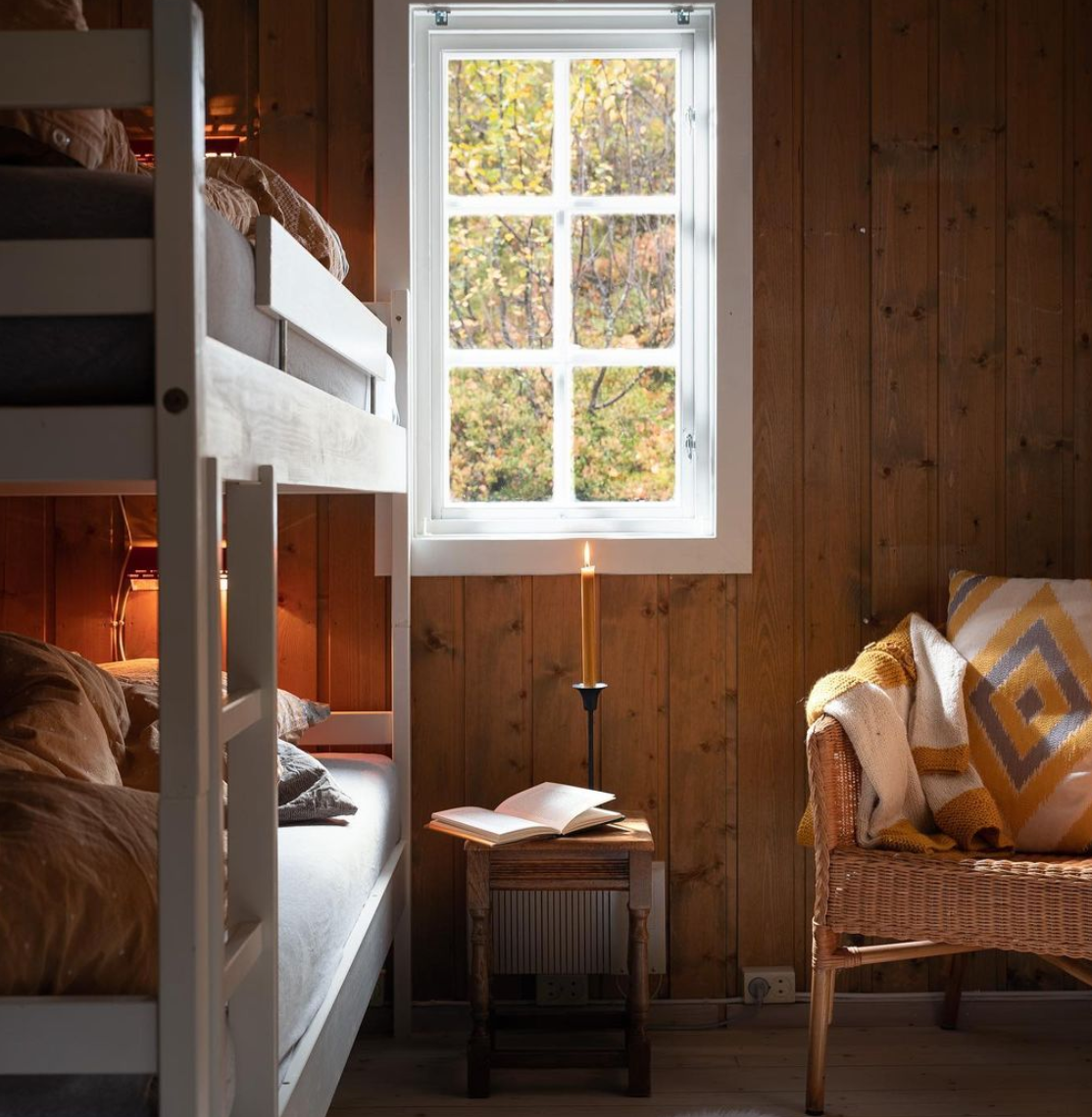 Cozy Friluftsliv bedroom complete with wooden bunk beds and an old candle.