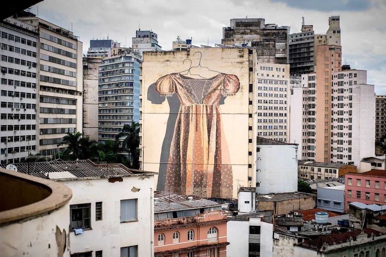 A Hyuro mural of an empty dress on a hanger, painted ten stories high for the CURO festival in Brazil.