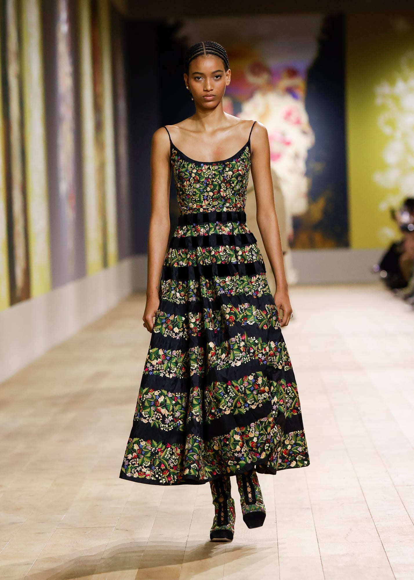 Dior model sports a dress covered in Ukrainian peasant flower motifs for Paris Fashion Week July 2022.