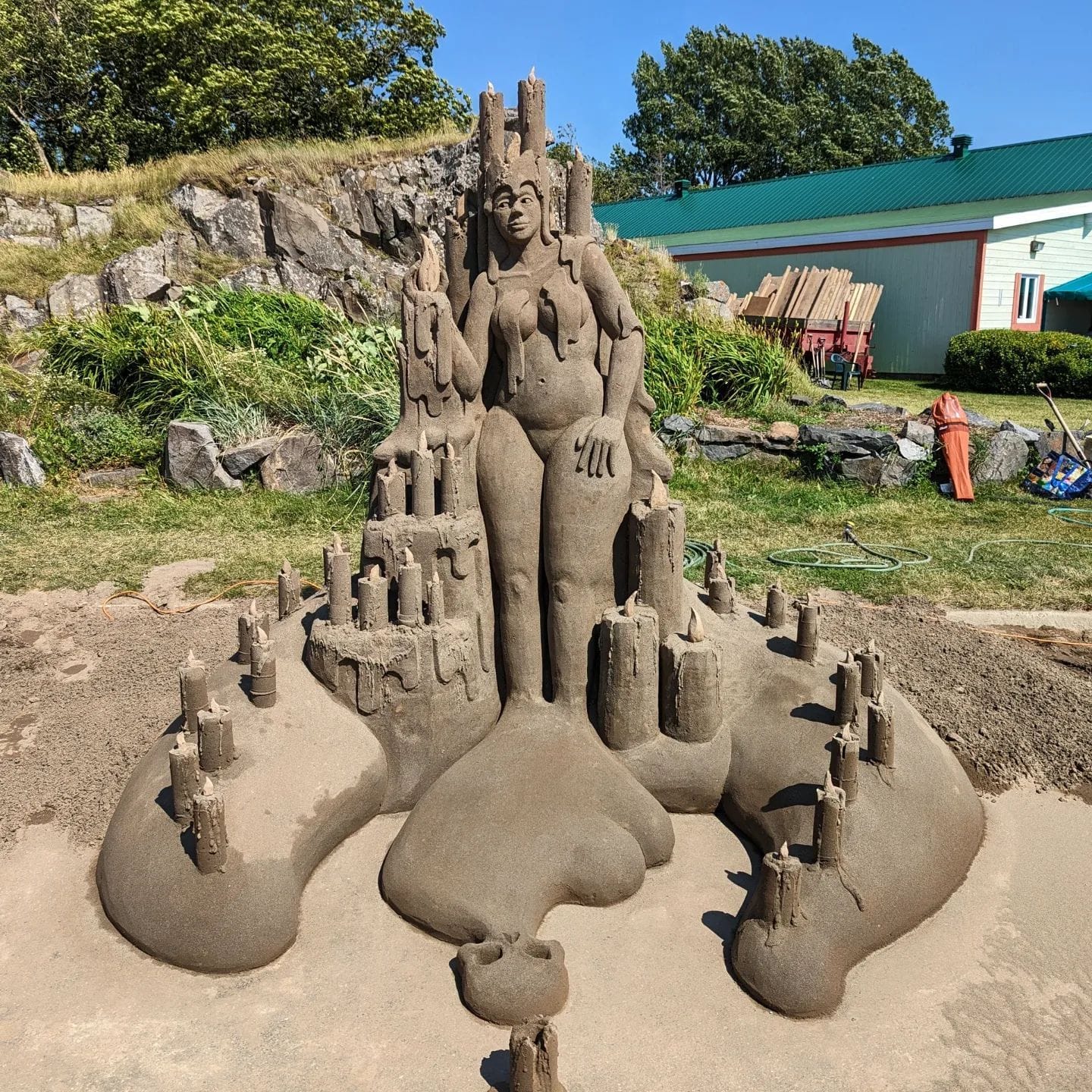 Sea lady sand castle sculpture by Guy-Olivier Deveau, the centerpiece of a sandy shrine. 