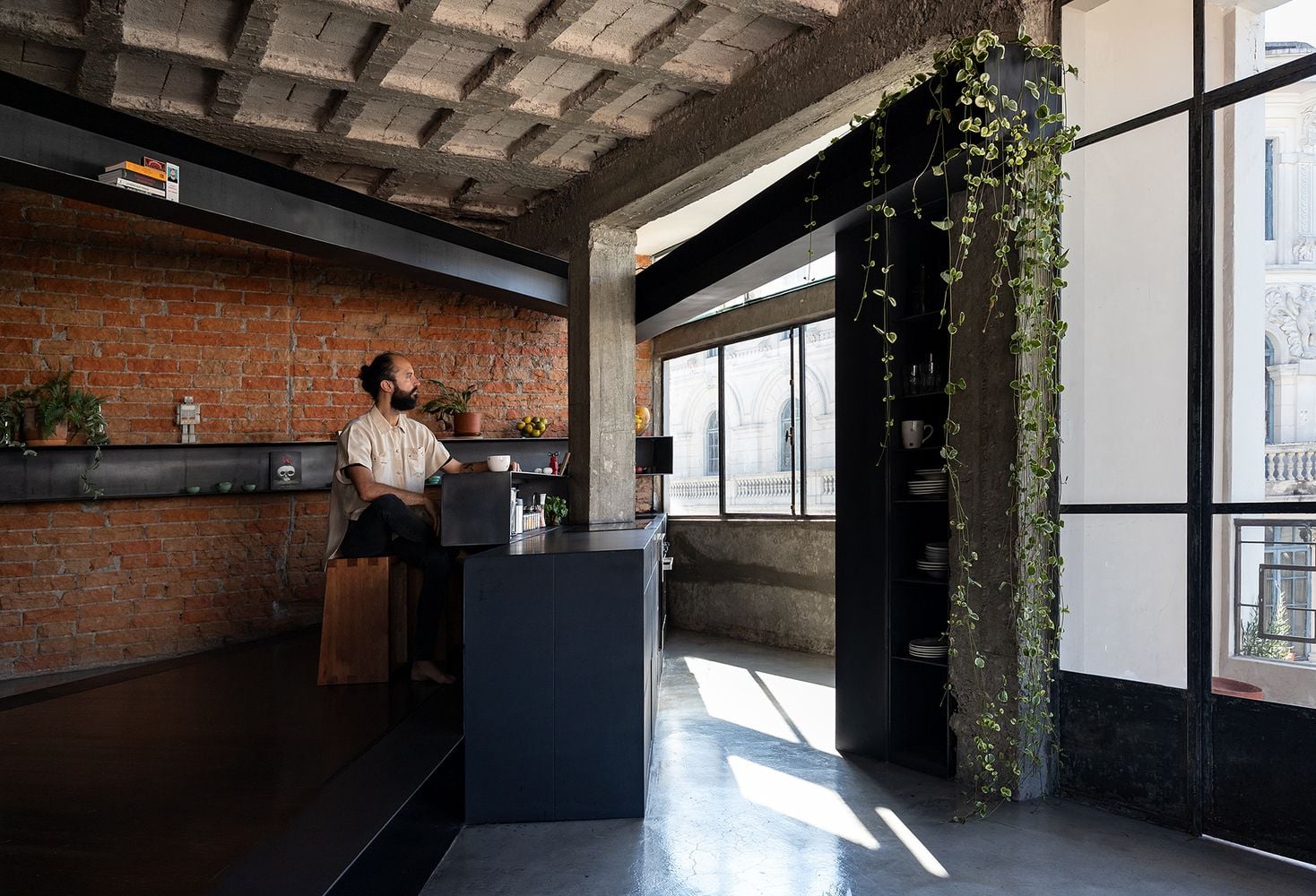 Subtle green accents, like the vine crawling down the beam on the right here, go beautifully with the apartment's brick and concrete textures. 