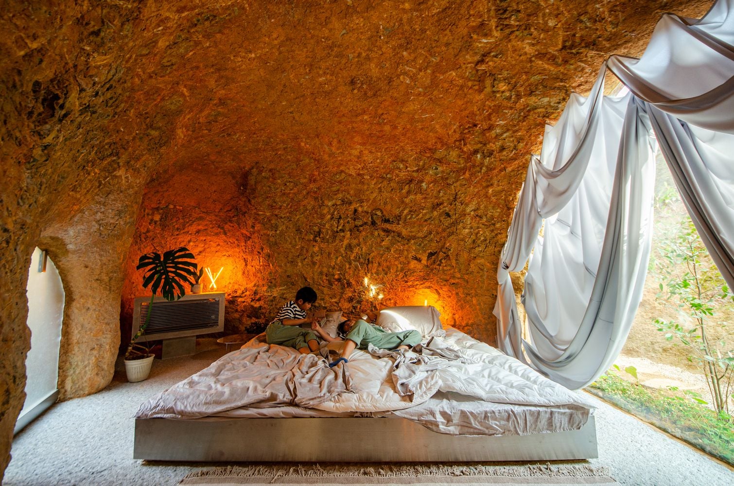 Gorgeous cave-like bedroom in the House and Restaurant Cave leaves one wall out for exposure to the surrounding nature.