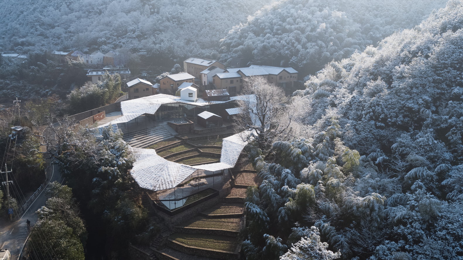 Aerial view of the Sou Fujimoto-designed Flowing Cloud pavilion while snow is falling.