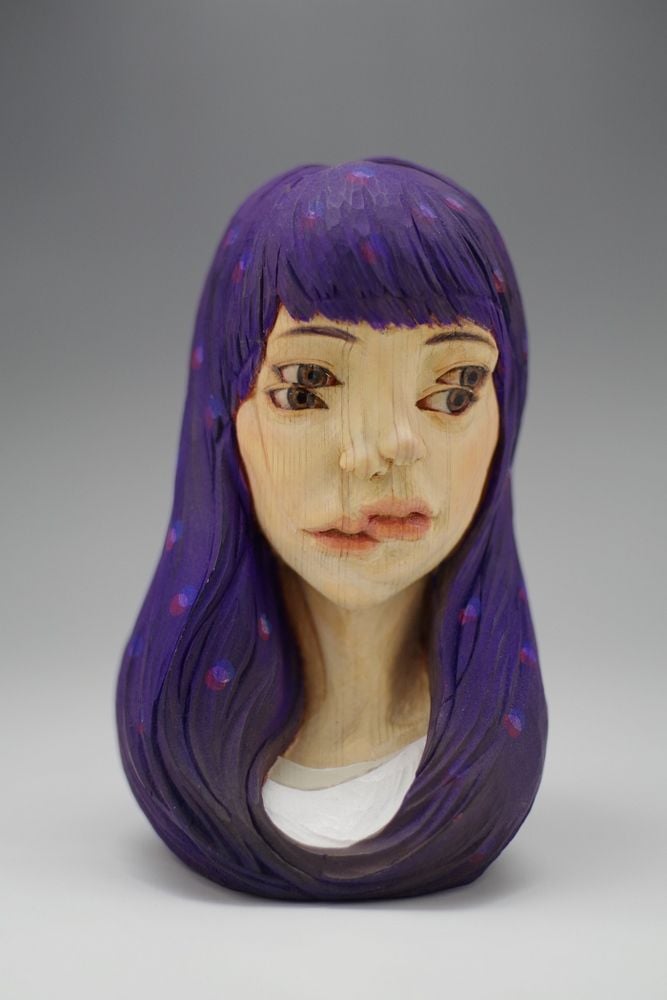 Surreal sculpture of a girl with 4 eyes, 2 noses, and 2 mouths, carved and painted by Yoshitoshi Kanemaki.