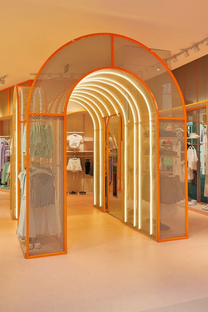 Bright orange entry arch starts shoppers on their surreal Mango Teen journey.