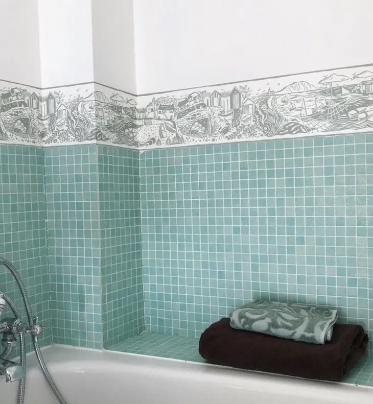 Wallpaper Border in the Bathroom Wallpaper border in a contemporary bathroom space depicts coastal and farmland settings.