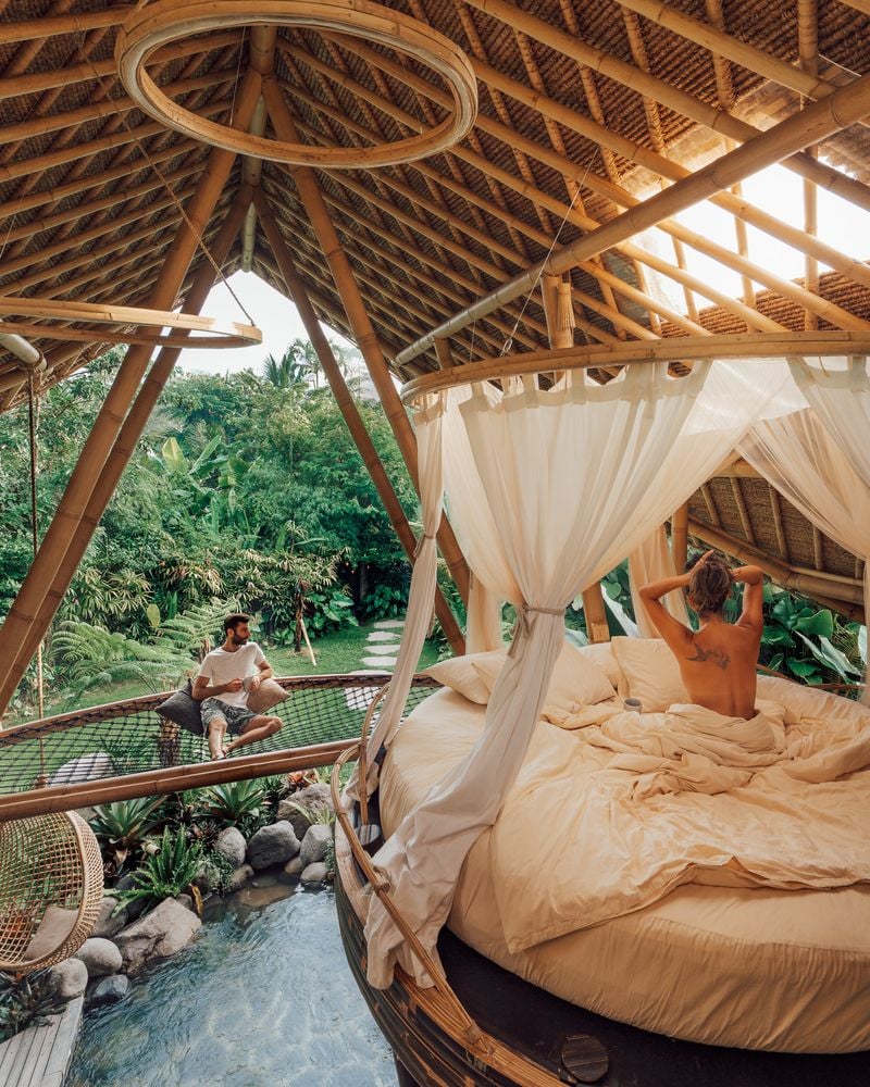 Youn couple hangs out in the hammock and bed area of the Hideout Horizon's second story.