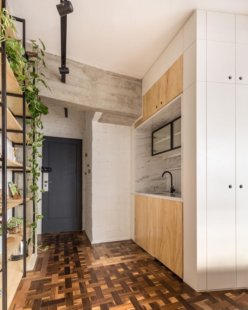 The tiny apartment's entryway also doubles as a small kitchen, though it's all tied together seamlessly by some beautiful textural flooring. 