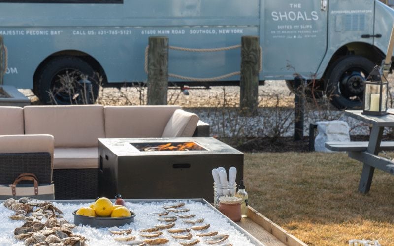 Oysters over ice sit in front of a fire pit and the Shoals food truck. 