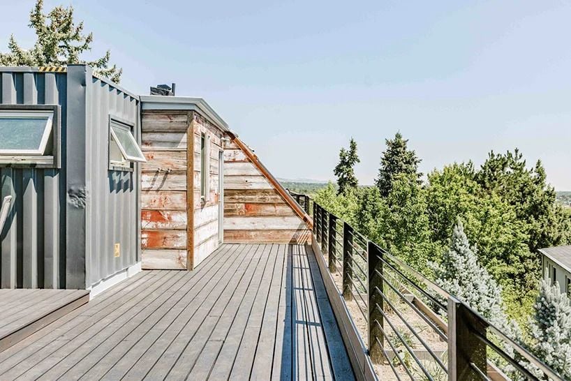 A simple wooden deck graces the rooftop of the Boulder shipping container home.