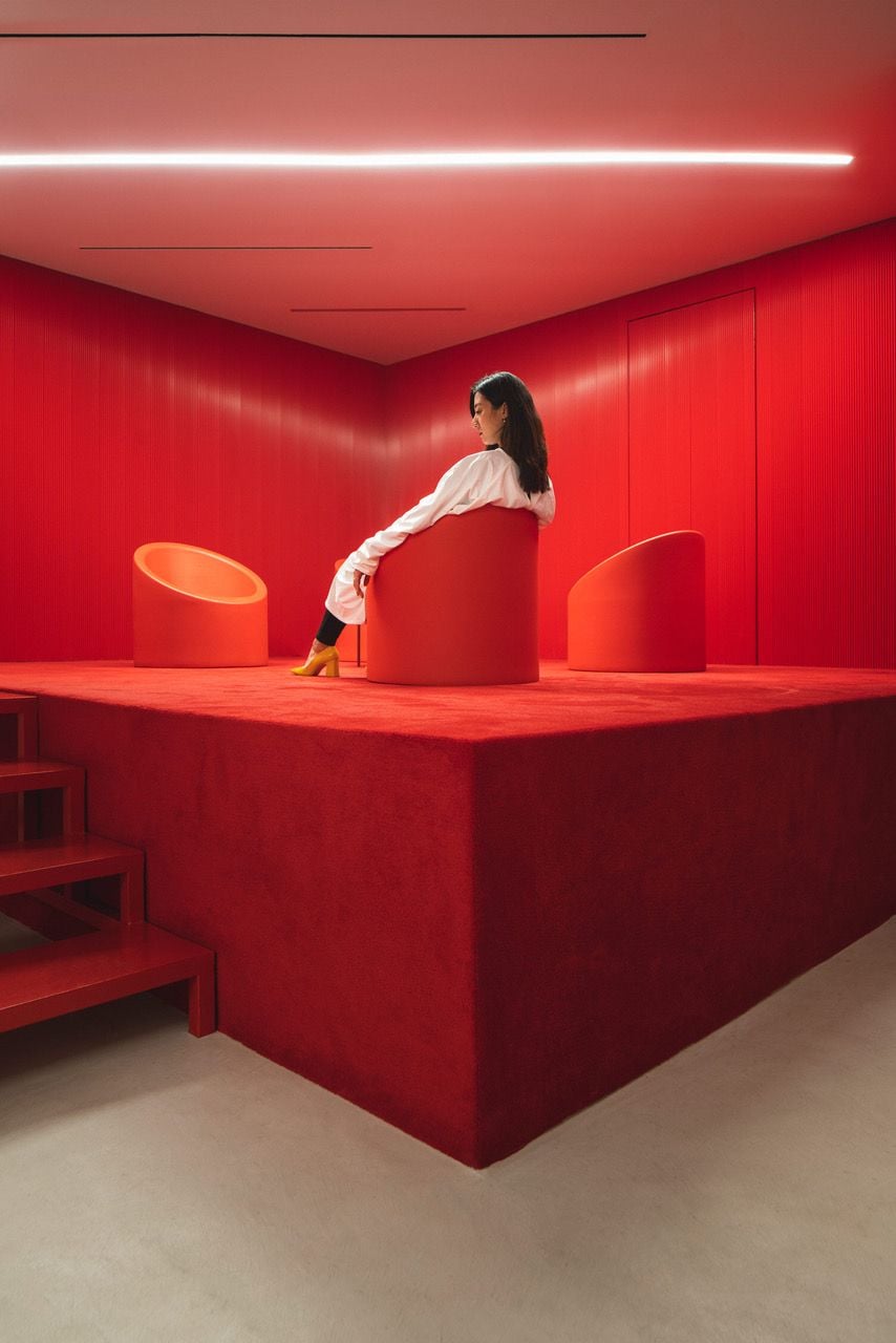 Dentist poses ominously in the Impress' dental clinic's blood red waiting room, itself inspired by David Lynch's 